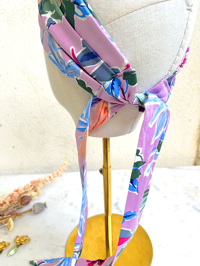 Colorful floral scarf tied in a knot around a dress form mannequin head