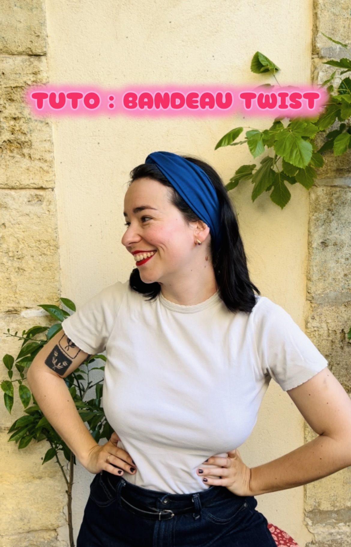 Woman with a blue headband smiles against a beige stone wall; pink neon text reads 'TUTO : BANDEAU TWIST' overlays the scene.